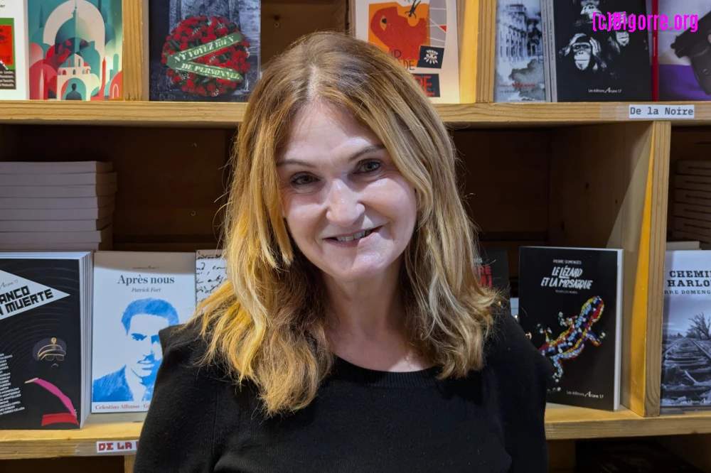 Marie-Pierre Vieu devant une bibliothèque pleine de livres édités par Arcane 17