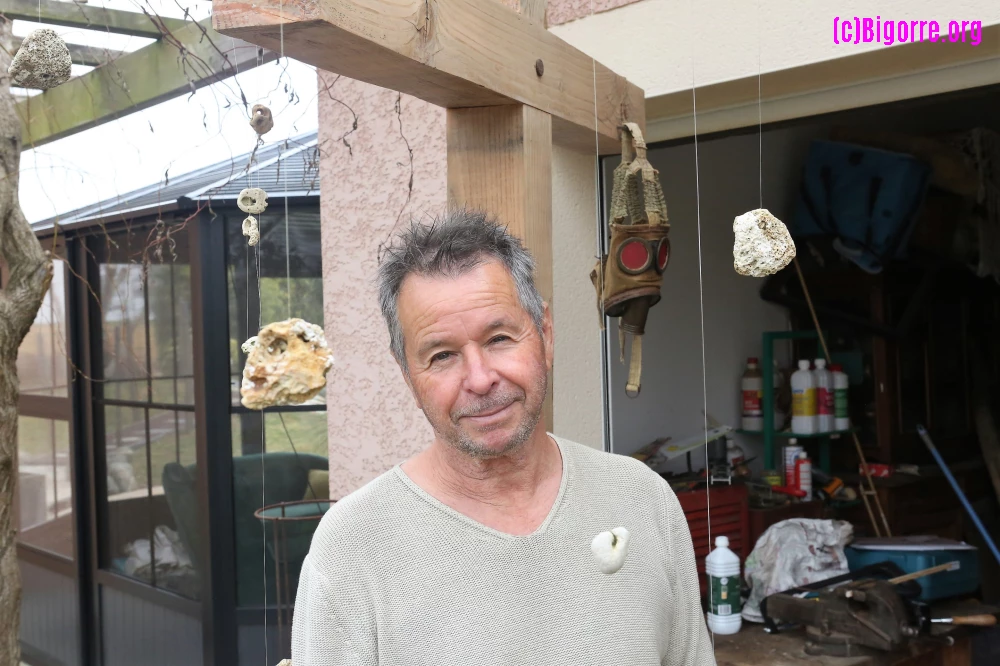 André Cazé devant sa croix au masque à gaz sortie de son garage