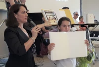 Christine Eynard et une collègienne de Desaix présentent un livre que seul les non-voyants peuvent voir/ Murielle Santos