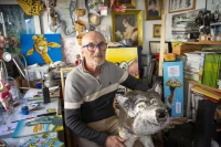 Xavieu Saüt dans son atelier, entiyré de BD et d'animaux en papier maché