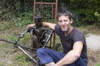 Pedro Fremy assis aux coté de Vétéran dans le jardin de son atelier à Agos-Vidalos/ photo de Stéphane Boularand (c)Bigorre.org