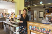 Karine Depeyre au Kairn, entre l'espace librairie et le comptoir du bistrot/ photo de Stéphane Boularand (c)Bigorre.org